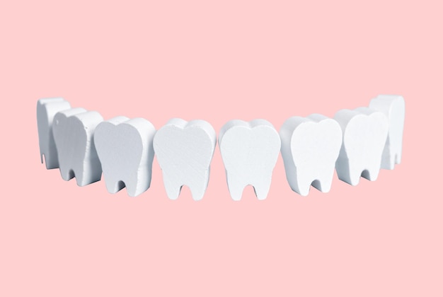 Białe zęby na różowym tle w formie uśmiechu Stomatologia koncepcja higieny jamy ustnej higiena jamy ustnej Profesjonalne czyszczenie lub leczenie zębów