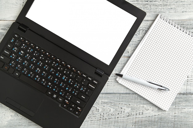 Białego papieru Notepad i laptop na rocznika podławym białym drewnie, odgórny widok