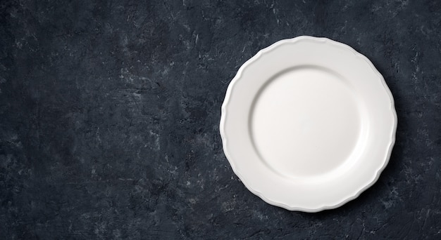 Białego rocznika ceramiczny pusty talerz na zmroku kamieniu