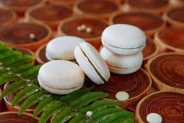 Biali waniliowi macaroons na drewnianym tle. pyszny deser. Wykonany ręcznie