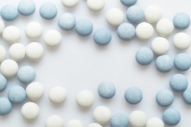 Biało-niebieskie tabletki na jasnej powierzchni