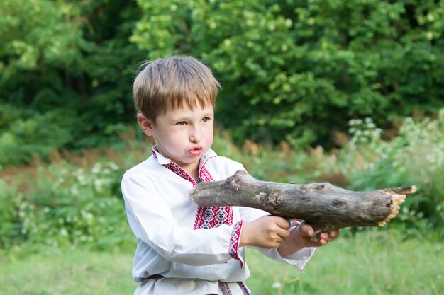 Białoruski chłopiec bawi się kijem jak pistoletem Własnoręcznie wykonane drewniane zabawki