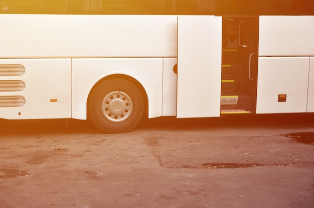 Biały autobus turystyczny na wycieczki. Autobus jest zaparkowany na parkingu w pobliżu parku