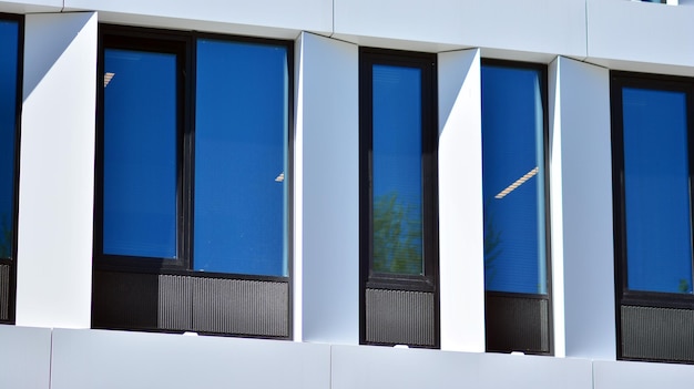 biały budynek z niebieskimi oknami i niebieskim szklanym oknem