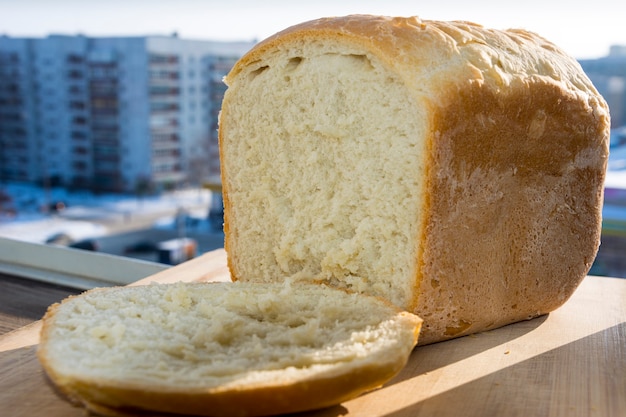 Biały domowy chleb z kawałkiem na oknie.