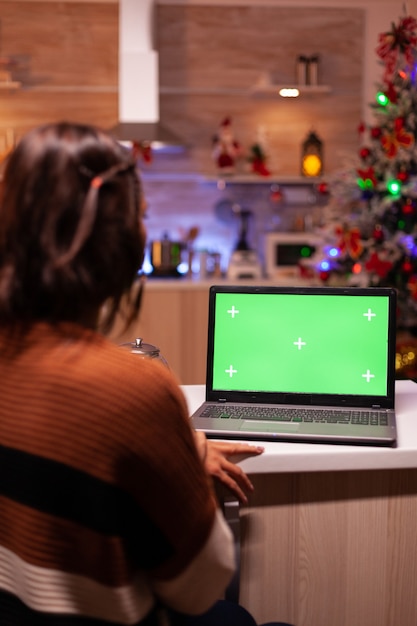 Biały dorosły patrzy na laptop z zielonym ekranem
