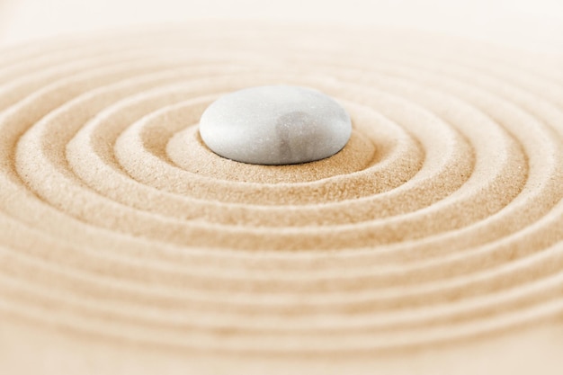 Biały kamień na piasku Zen scena w ogrodzie japońskim w tle