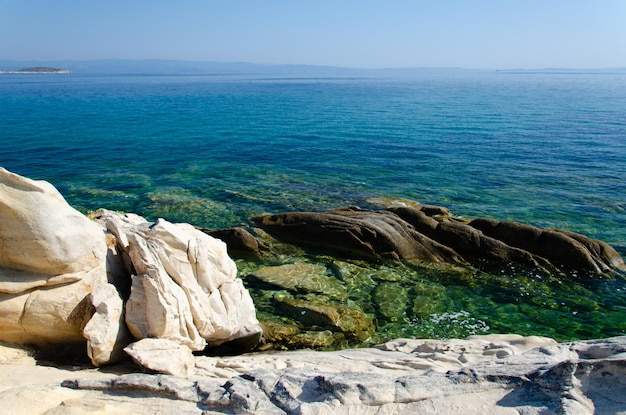 Biały kamienny brzeg i błękitne morze Plaża Karidi Halkidiki Można zobaczyć skaliste dno w czystej wodzie