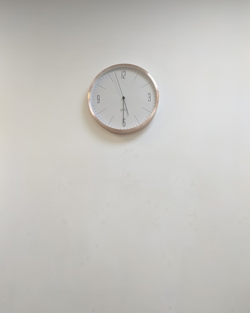 Biały klasyczny okrągły zegar na szarej ścianie Kopiuj przestrzeń bez ludzi Projekt minimalizmu biurowego