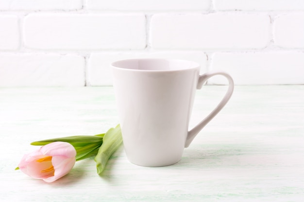 Zdjęcie biały kubek kawy z różowym tulipanem