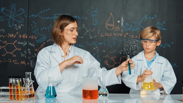 Zdjęcie biały nauczyciel pomaga uczniowi w mieszaniu płynów w laboratorium naukowym