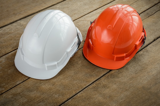 Biały, pomarańczowy kask ochronny do hełmu dla projektu bezpieczeństwa robotnika jako inżyniera lub pracownika
