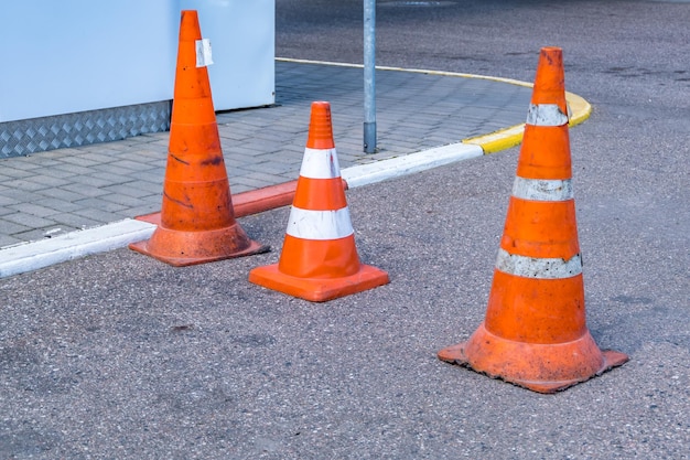 Biały pomarańczowy stożek zagrożenia ruchu na naprawie asfaltowej drogi