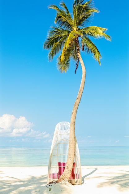 Biały ratan krzesło pod drzewkiem palmowym na perfect tropikalnej plaży, wakacje letni pojęcie