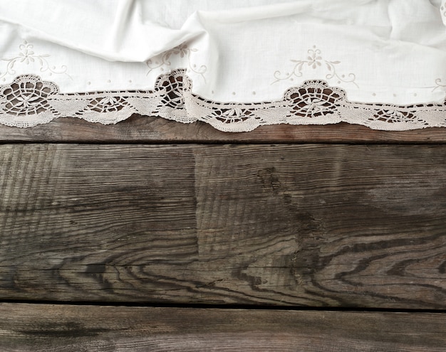 Biały ręcznik tekstylny kuchenny składany na szarym drewnianym stole