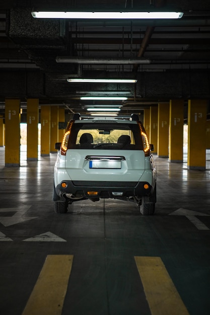 Biały samochód suv na parkingu podziemnym