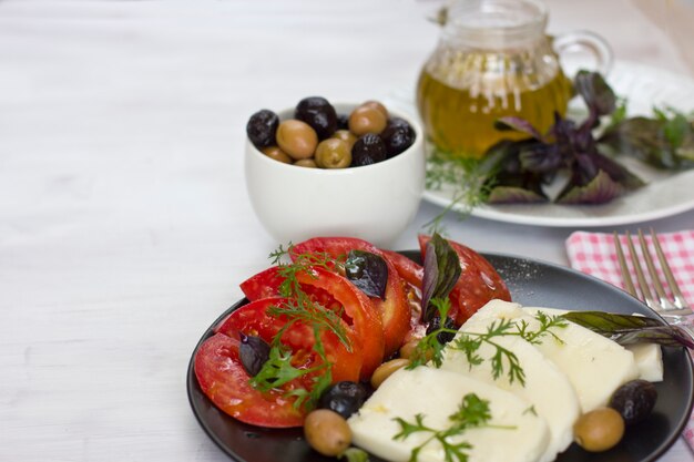 Biały ser z pomidorami, zielonymi i czarnymi oliwkami, bazylią, kolendrą i oliwą z oliwek
