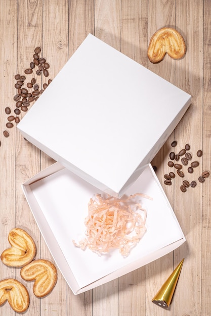 Zdjęcie biały wzór pudełka między różnymi słodyczami na stole i figurami