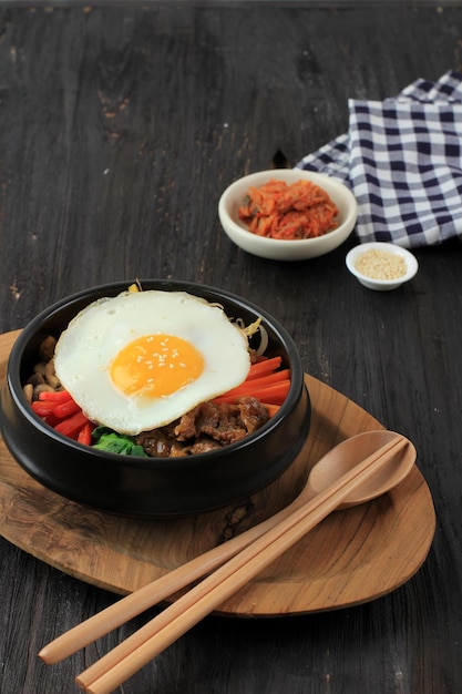 Bibimbap Ryż Koreański z Mieszanką Warzyw Sautee, Wołowiną i Jajkiem Sunny Side. Podawany z Czerwonym Pikantnym Sosem Bibimbap i Olejem Sezamowym. Kopiuj miejsce na tekst