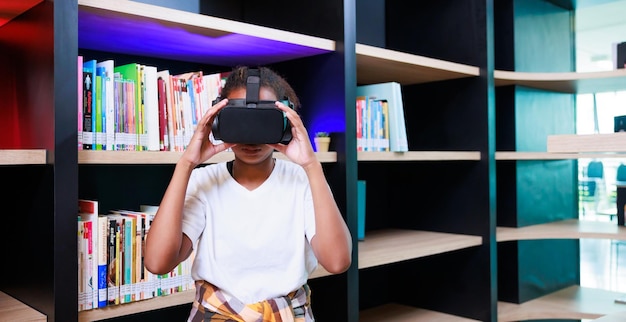 Biblioteka słuchawek VR Młoda uczennica szkoląca się i ucząca się z wirtualnym zestawem słuchawkowym VR w szkolnej bibliotece