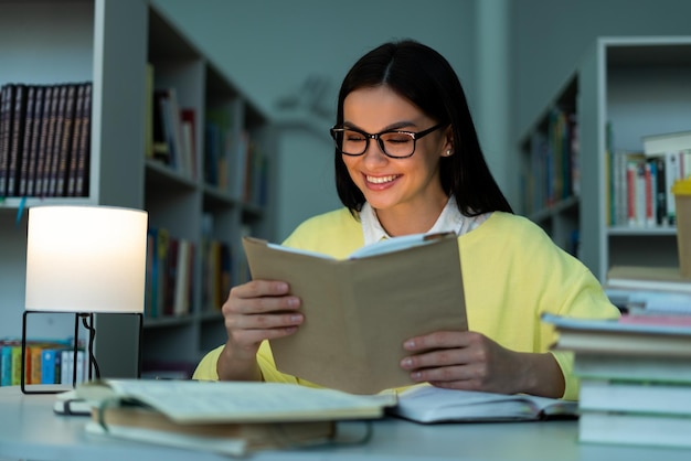 Biblioteka uniwersytecka utalentowana kaukaska dziewczyna siedząca przy biurku czytająca lektura boo do zadania klasowego Studentka ucząca się do egzaminów