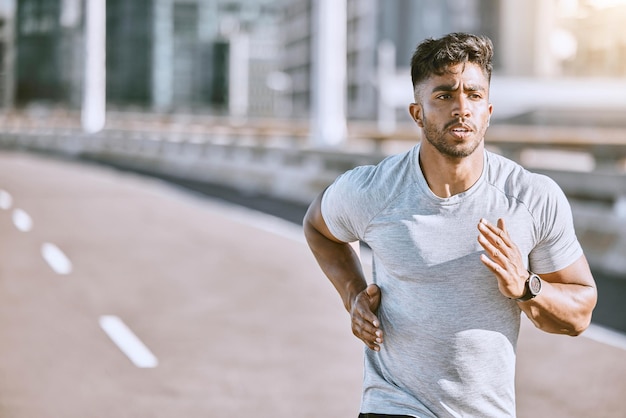 Biegacz biegający do treningu fitness na ulicy w mieście miejskim, wykonujący ćwiczenia cardio i sport na ulicy