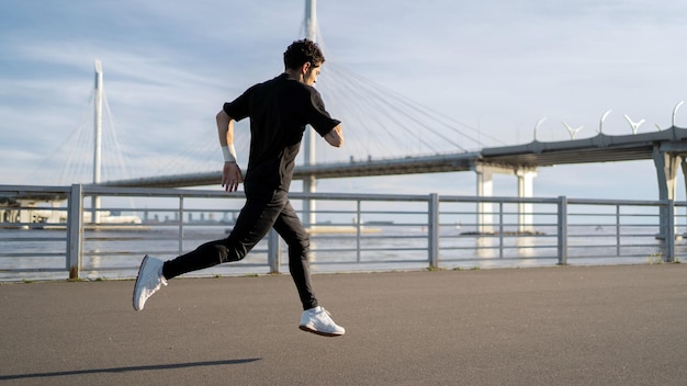 Biegacz męski sportowiec biegający wykonuje ćwiczenie treningowe w mieście używa zegarka fitness