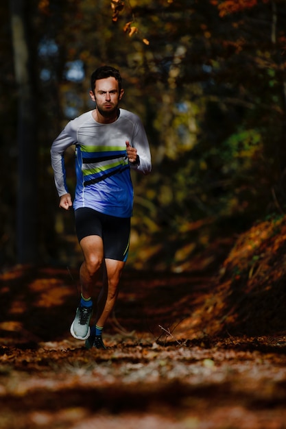 Biegacz Podczas Przygotowań Do Maratonu W Lesie Jesienią