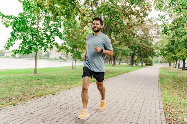 Biegacz wykonujący ćwiczenia joggingowe Trener płci męskiej jest wytrzymały Sportowy mężczyzna w odzieży sportowej