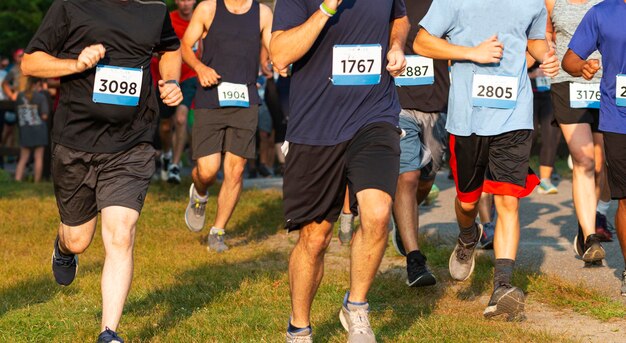 Zdjęcie biegacze biegający w wyścigu 5 km na trawie podczas bardzo zatłoczonego wydarzenia