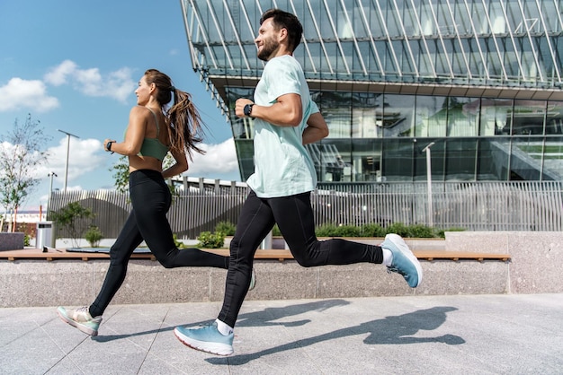 Biegacze to młoda para trenująca na ulicy sportowcy są przyjaciółmi biegających ćwiczeń fitness