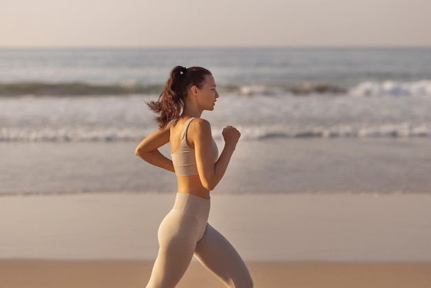 Biegaczka biegająca na plaży podczas ćwiczeń na świeżym powietrzu