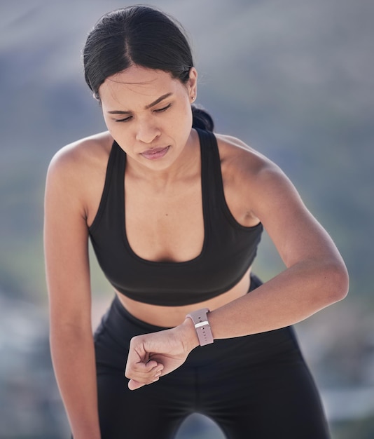 Biegająca kobieta i sprawdź inteligentny zegarek na świeżym powietrzu pod kątem tętna i sprawności fizycznej