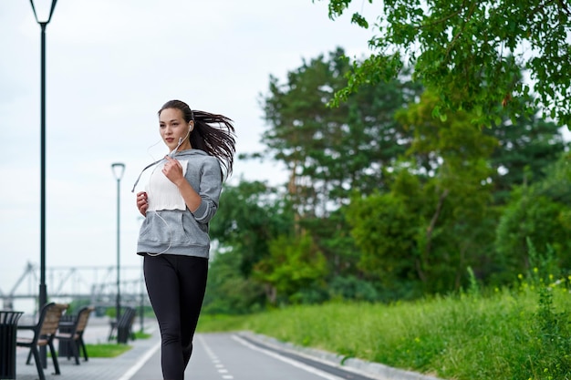 Biegnąca Azjatka na nabrzeżu Poranny jogging Sportowiec trenuje