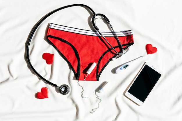 Bielizna damska stetoskop smartfon i termometr Koncepcja telemedycyny zdrowia kobiet Tele zdrowie menopauza i dni krytyczne ból brzucha cykl menstruacyjny ginekologia ciąża