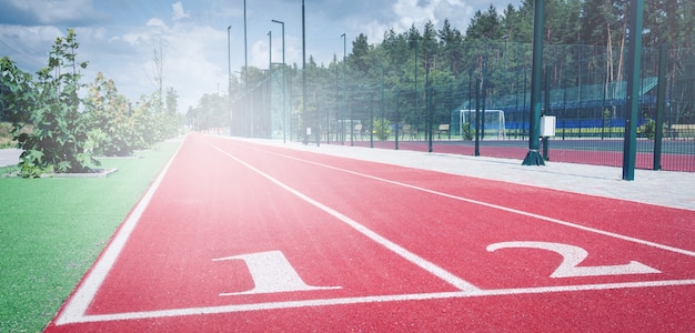 Bieżnia na stadionie sportowym. Powłoka gumowa. Zawody lekkoatletyczne na linii startu. Stadion szkolny.