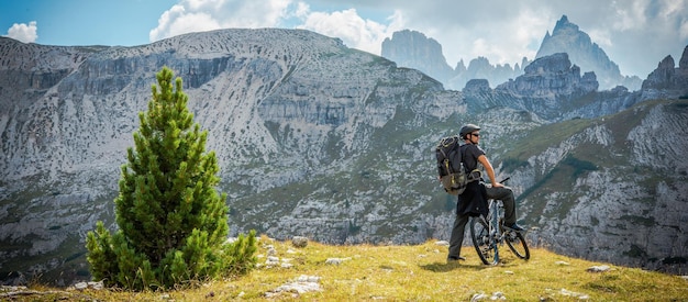 Zdjęcie biker kaukazyjski na szlaku górskim panoramiczne zdjęcie włoskie dolomity