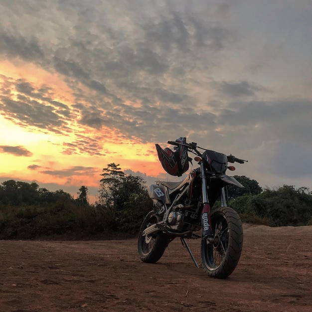 Biker Supermoto z krajobrazem zachodu słońca