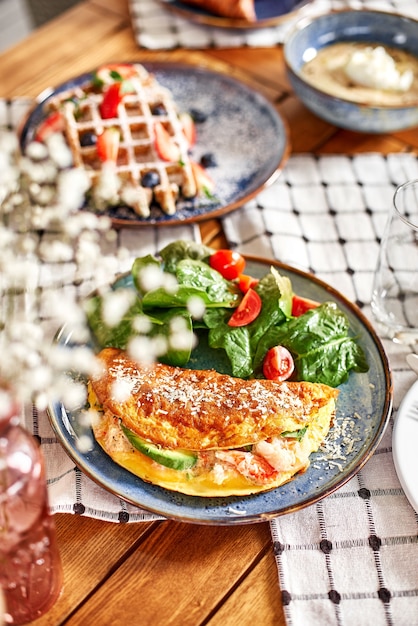 Bio zdrowe jedzenie - świeży omlet z sałatką. Serwowany stolik w kawiarni na tarasie letnim, czas na śniadanie lub lunch