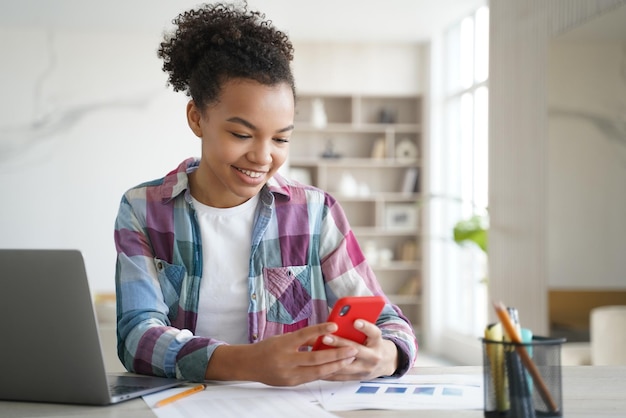 Biracial nastolatka trzyma telefon odwrócona od nauki Uzależnienie od sieci społecznościowych nadużywanie gadżetów