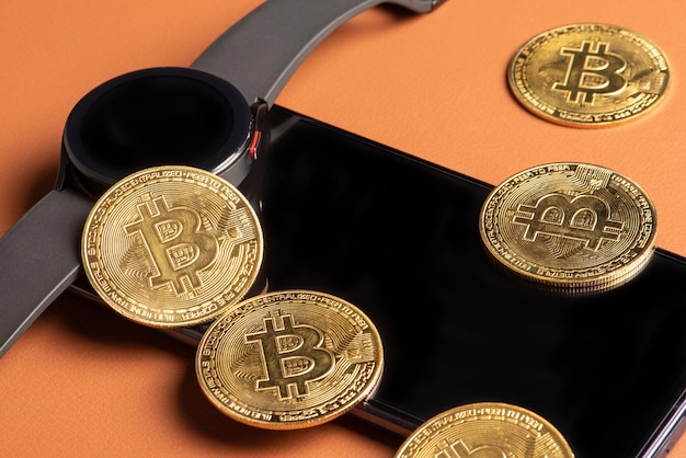 Bitcoin bitcoin monety smartfon i inteligentny zegarek umieszczone na brązowym skórzanym tle selektywnej ostrości