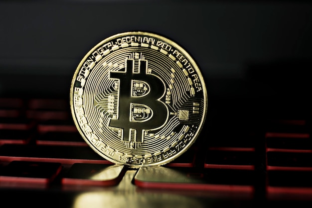 Bitcoin krypto moneta na tle klawiatury laptopa