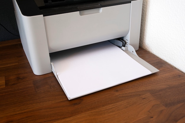 Zdjęcie biurowa drukarka cyfrowa, kopiarka i papier na drewnianym biurku, zbliżenie faksu