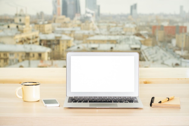 Biurowy pulpit z pustym białym laptopem