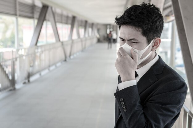 Biznes azjatyckiego mężczyzny w mieście tajlandiaPrzystojny mężczyzna noszący maskę medyczną chroniącą przed wirusem covid19 lub koronawirusem od Zarażona osobakoronachroniona Pomóż chronić Dla świata i ludzi zatrzymaj ostrzeżenie o wirusie