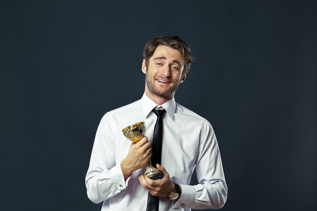 biznes człowiek trzyma złoty puchar trofeum