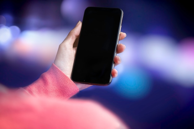Biznes kobieta na ulicy w nocy za pomocą smarthphone - makieta telefonu - efekt bokeh.