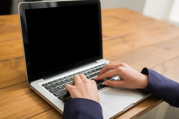 Biznes kobieta pracująca w biurze, pisząca na laptopie, zbliżenie, niewielka głębia ostrości