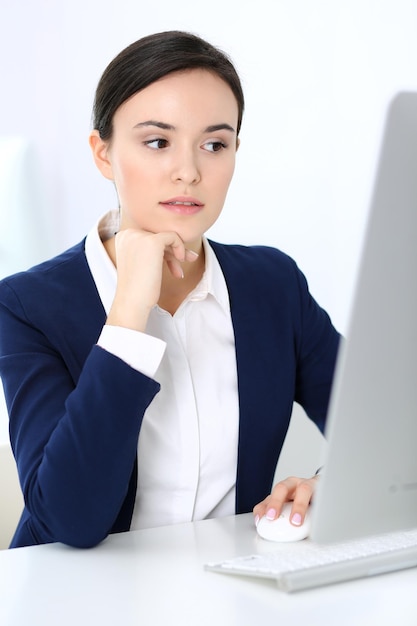 Biznes kobieta pracuje z komputerem w biurze Headshot prawnika lub księgowego w pracy siedząc przy biurku