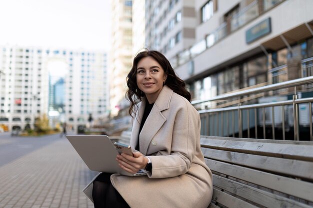 Biznes kobieta siedzi z laptopem poza biurową koncepcją pomyślnego rozwoju biznesu